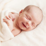 Newborn baby girl asleep on a blanket: A list of new baby newborn essentials for new parents