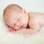 Newborn essentials list for parents: adorable baby sleeping on stomach
