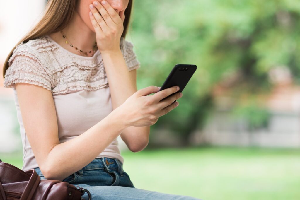 Surprised woman looking at her mobile phone