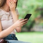 Surprised woman looking at her mobile phone